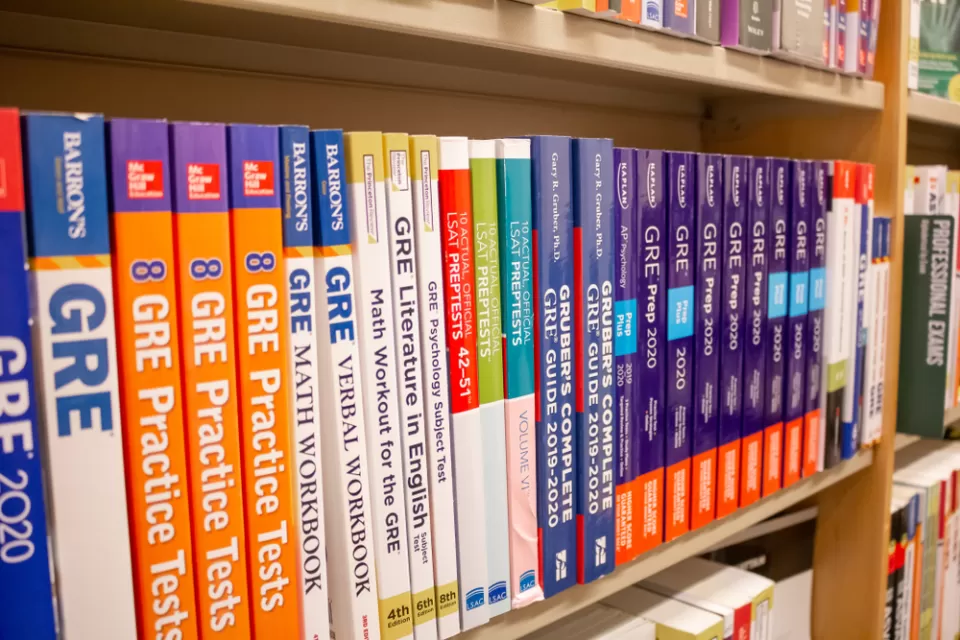 A row of GRE exam study books lined up neatly in a bookstore.
